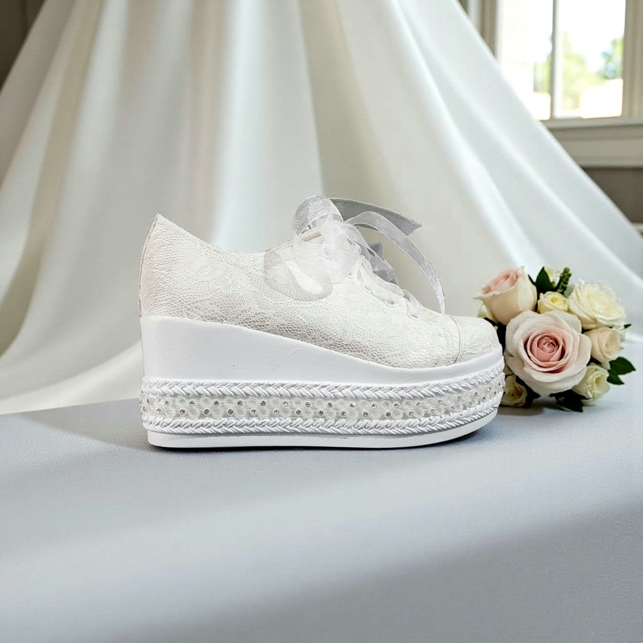 White  Bridal wedding shoe with platform and decorative elements on a light background