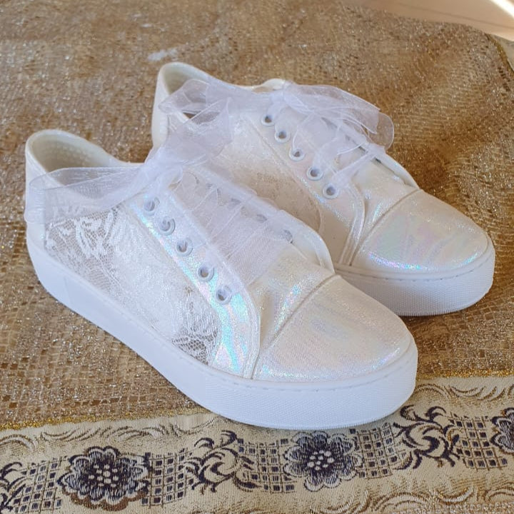 White Lace Bridal  sneakers with lace details on a patterned tablecloth