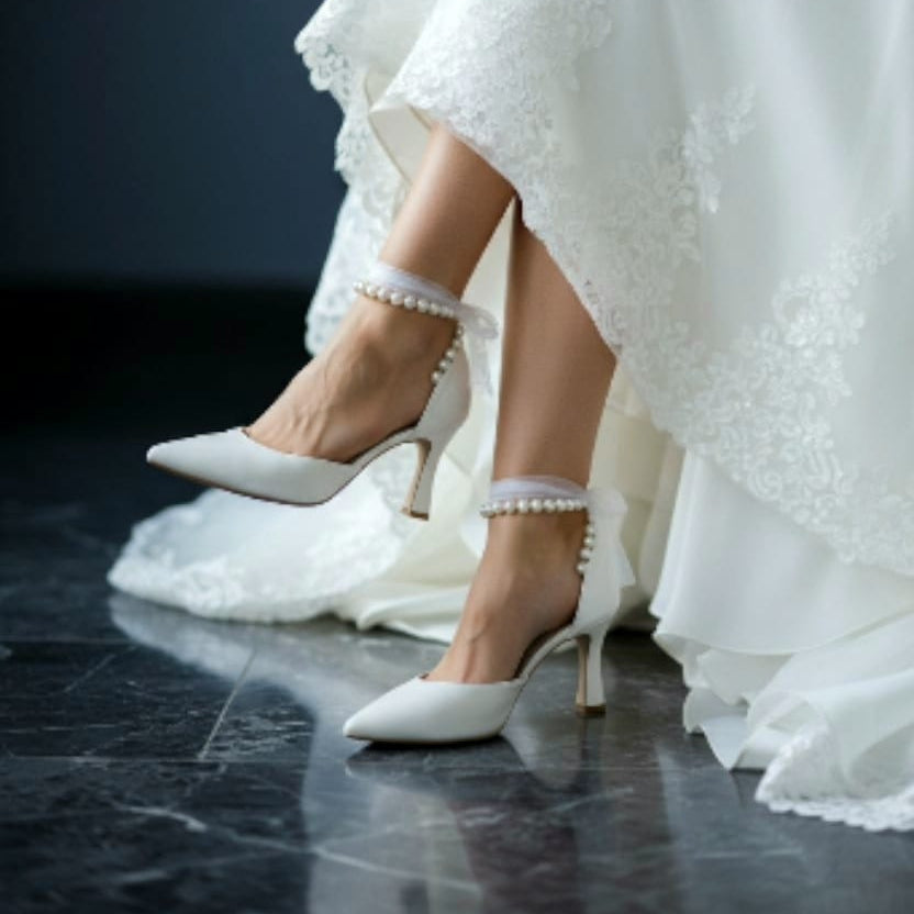 White wedding dress with high-heeled shoes on a dark floor